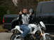 2003 Buell Lightning w/Fairing - A man sits on a white 2003 Buell Lightning motorcycle, giving the finger, with a black pickup truck behind him.