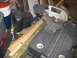 2004 Aston Martin Virage - A miter saw is positioned next to lumber and other items in what appears to be a workshop or garage.