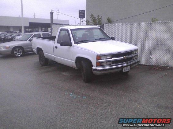 White pickup truck parked next to a silver sedan