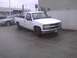 2003 Ford Crown Victoria - White pickup truck parked next to a silver sedan in a lot.