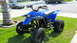 2003 Yamaha BLASTER - A blue all-terrain vehicle is parked on a grassy lawn in front of a house.