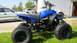 2003 Yamaha BLASTER - A blue ATV is parked on grass with cars and a trailer in the background.