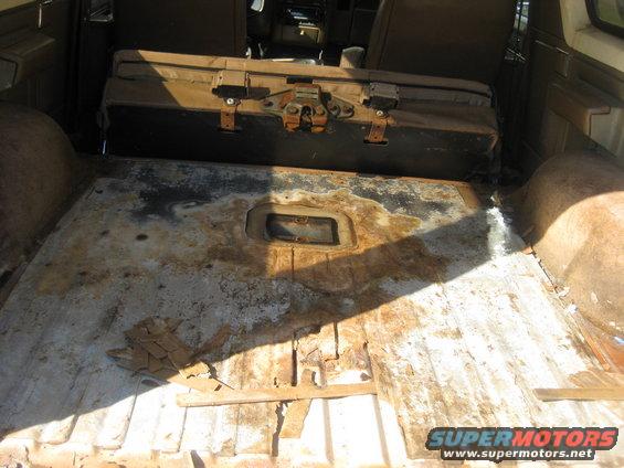 img_0802.jpg Cargo area with carpet removed. Any water that leaked in would gather in the recess for the rear seat latch.