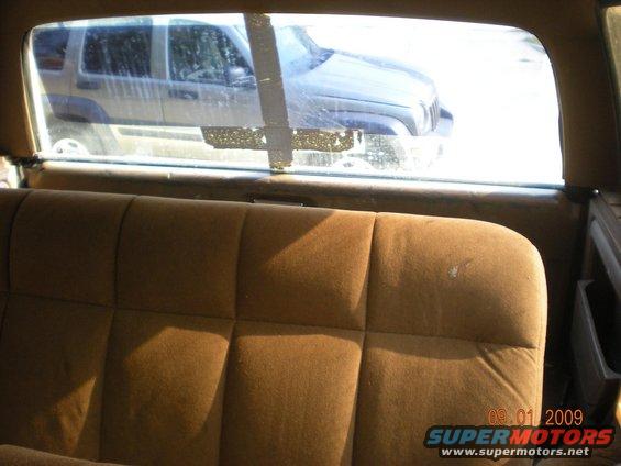 Interior view of a vehicle looking out the rear window at a Jeep Liberty