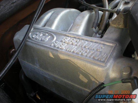 Close-up of a silver Ford intake manifold with 'ELECTRONIC FUEL INJECTION' text