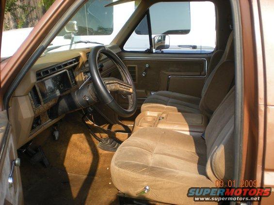 1986 Ford Bronco interior, showing brown velour seats, dashboard, and steering wheel