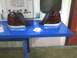 2003 Ford Crown Victoria - Pair of car tail lights displayed on a blue table in a workshop setting.
