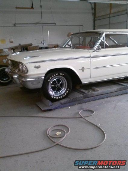 1961 Ford Falcon on a lift, front quarter view. Goodyear Eagle ST tire visible