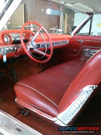 Red interior of a 1960 Ford Falcon with bench seat and dashboard