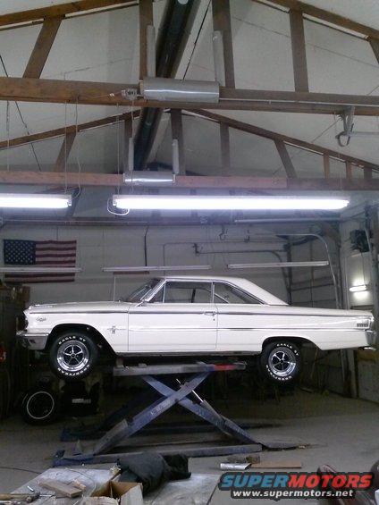 White 1963 Ford Galaxie coupe on a car lift, side view