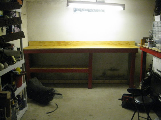 Workbench with a car transmission on the floor next to it