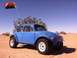 1970 Volkswagen Beetle - Modified Volkswagen Beetle with off-road tires and a lifted suspension sits in a sandy desert landscape.