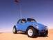 1970 Volkswagen Beetle - A blue 1970 Volkswagen Beetle dune buggy is driven across sandy terrain under a clear blue sky.