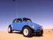 1970 Volkswagen Beetle - A blue off-road vehicle with a person driving is on a sandy terrain under a clear blue sky.