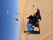 1970 Volkswagen Beetle - Two people are on a blue dune buggy on sand dunes under a clear blue sky.