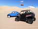 1970 Volkswagen Beetle - A blue 1970 Volkswagen Beetle and a black UTV are parked in the sand dunes under a bright blue sky.