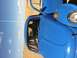 1970 Volkswagen Beetle - A driver sits in a bright blue custom vehicle, with a sandy desert and sky in the background.