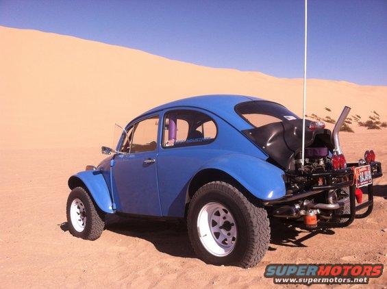 Blue Baja Bug with off-road tires and exposed engine in desert