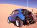 1970 Volkswagen Beetle - Modified 1970 Volkswagen Beetle Baja Bug parked in a sandy desert environment under a clear blue sky.
