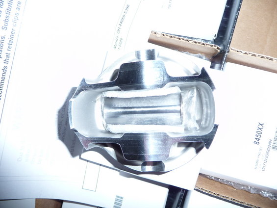Engine piston with bearing inserts, on top of some paperwork