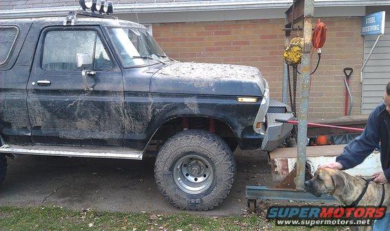 Black 1978 Ford Bronco with aftermarket bumper and roof lights, covered in mud