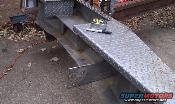 Metal ramp section with diamond plate surface, tape measure, and marker
