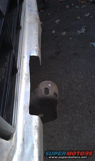 Chrome bumper section with a tow hitch receiver visible. Grille is partially in frame