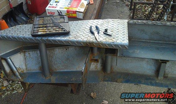 Diamond plate metal plow attachment with a set of drill bits and pliers on top