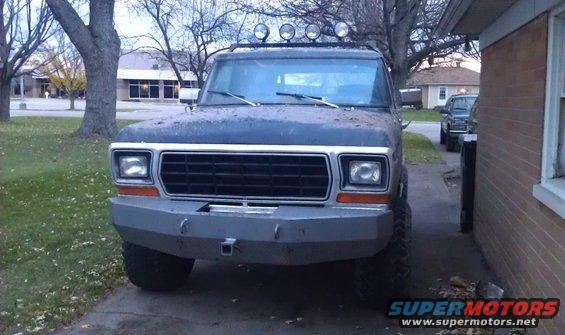 Dark blue 1978 Ford Bronco with aftermarket bumper and roof lights, parked in driveway