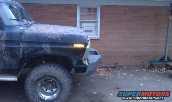 Black 1979 Ford Bronco front corner with aftermarket bumper and dirty hood