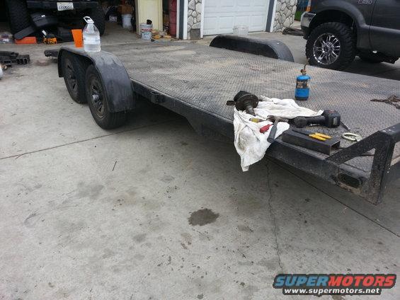 Trailer with tools, bottle of water, and a dark SUV in the background