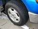2008 Ford Crown Victoria - Close-up of a blue Ford F-150's front wheel and fender area, showing a winter tire.