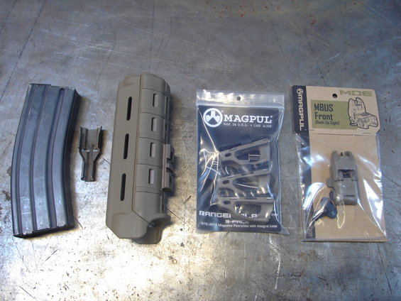 Tan Magpul foregrip, magazine, and MBUS front sight on a metal surface
