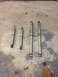 1996 Ford F-150 - Four shock absorbers of varying lengths are laid out on a concrete surface with scattered leaves.