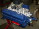 1987 Ford Mustang - A freshly painted Ford V8 engine sits on a red engine stand, ready for installation.