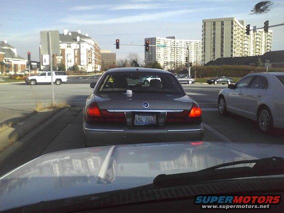Rear view of a Mercury Grand Marquis with a white cup on the trunk. License plate 494 2640