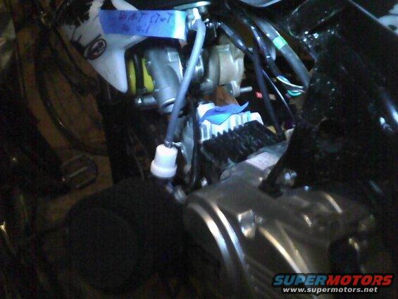 Engine compartment showing a fuel filter and blue tape with writing
