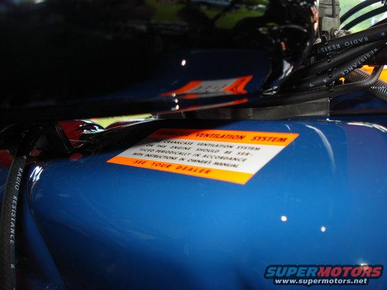 Orange sticker on blue engine component reads "Crankcase Ventilation System"