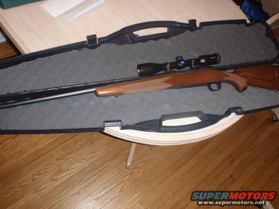 Rifle with scope in an open black case on a table