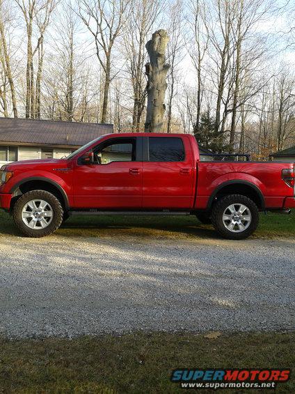 Red pickup truck parked on a gravel driveway, side view. This is not a 1978 Ford F-150