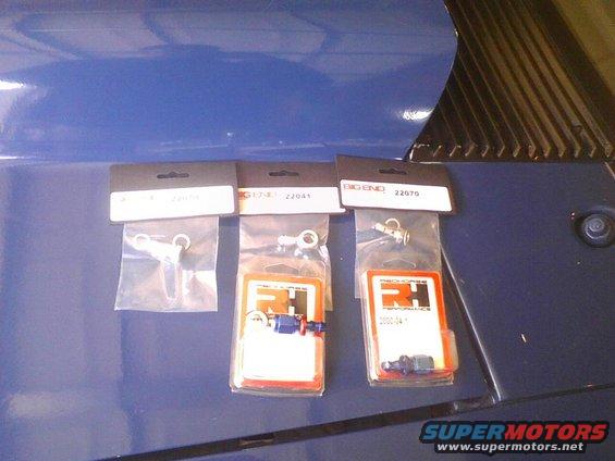 Three packages of automotive parts on a blue surface