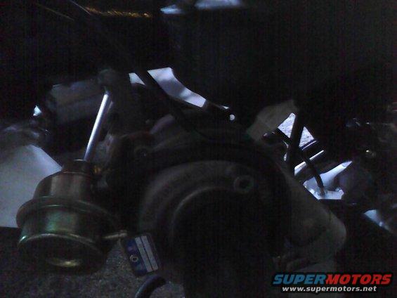 Turbocharger wastegate actuator with a blue and white label attached