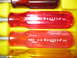 2004 Aston Martin Virage - Close-up view of multiple screwdrivers with translucent red handles and yellow accents.