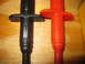 2004 Aston Martin Virage - Close-up of two Fluke brand test probes, one black and one red, resting on a wooden surface.