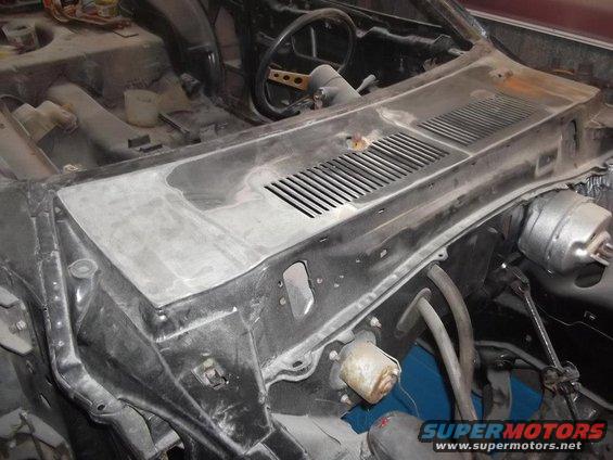 Car dashboard under repair, showing vents, steering column, and brake booster
