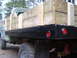 1979 Ford Bronco - A flatbed truck is seen from the side, loaded with wooden planks and red taillights.