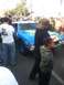 2004 Ford F-150 - A blue race car with racing stripes and decals is parked on a street surrounded by onlookers.