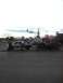 2004 Ford F-150 - A white pickup truck tows a race truck on a trailer down a street.