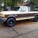 1984 Ford Bronco - This two-tone brown and tan pickup truck is viewed from the front three-quarter angle.