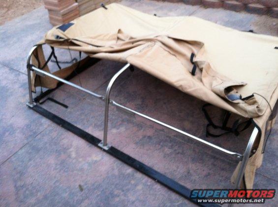 Tan truck bed cover with metal frame on concrete
